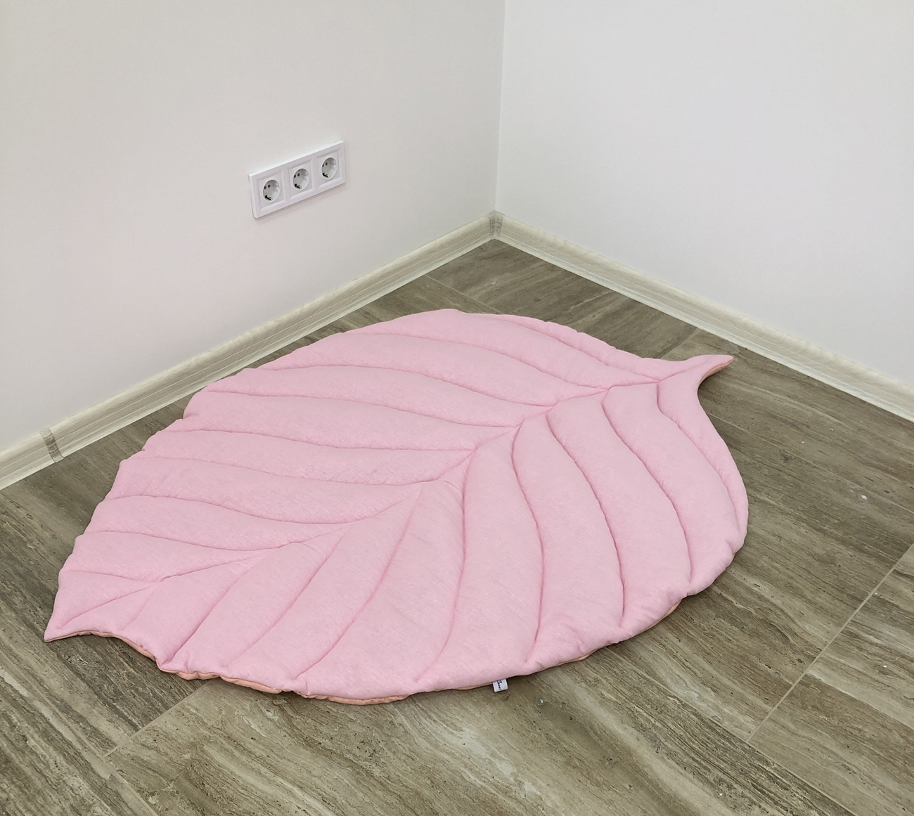 Pink play rug for the nursery in the form of a leaf