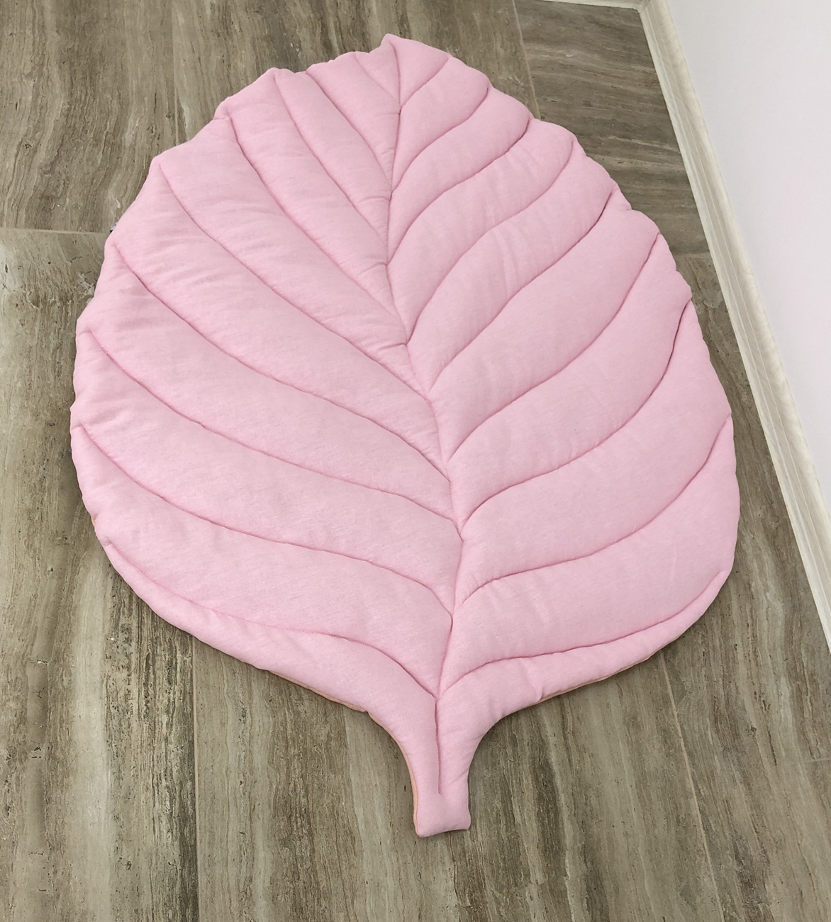 Pink play rug for the nursery in the form of a leaf