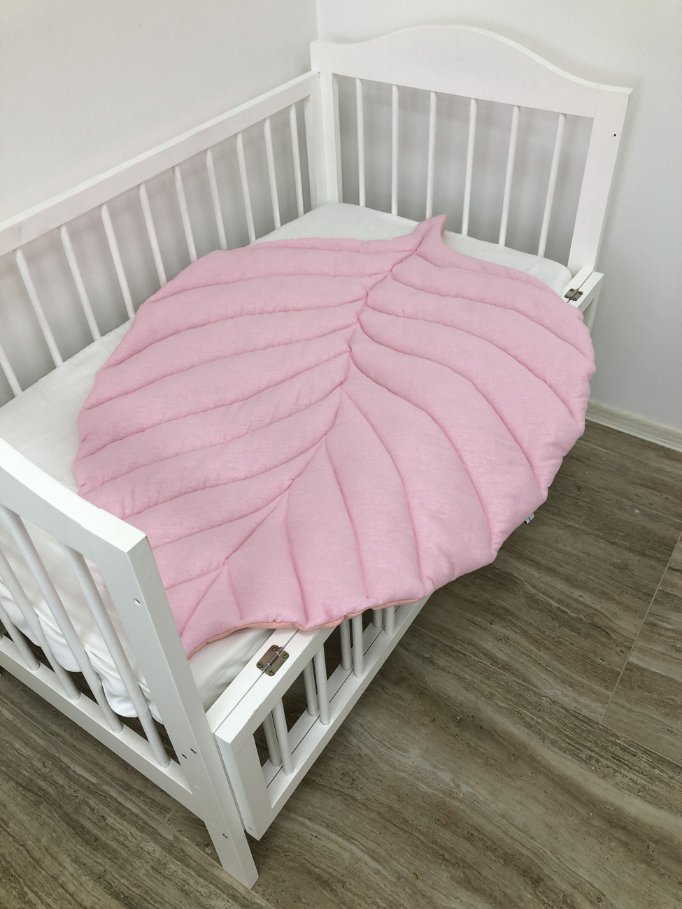 Pink play rug for the nursery in the form of a leaf